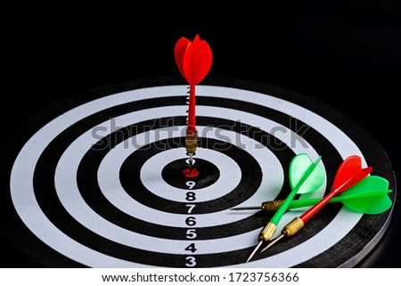Red and green dart arrow hitting target center Dart board Isolated on black background, Setting aim goal achievement concept challenging business goals And ready to achieve goal and Marketing concept