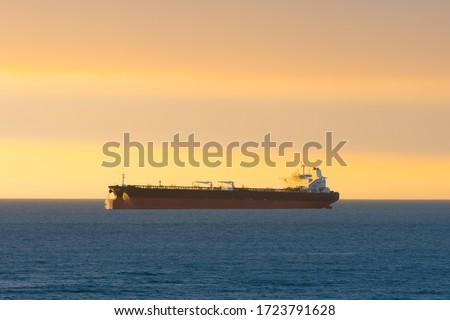 Cargo ship at sunset in the coasts of Chile outside the port of Valparaiso.