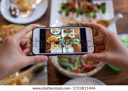 Take a photo of a smartphone for lunch or dinner. Woman taking picture with phone. Posting or sharing popular food for social media.