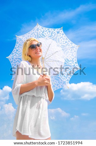 Woman with parasol against  sky. Photo of beautiful woman in vintage dress for promenade