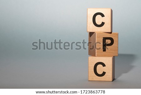 CPC word built with wooden cubes and black letters on grey background. Copy space available