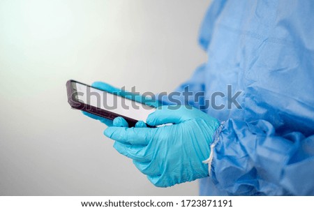 Doctor is wearing PPE suit and looking for corona/covid-19 virus infected patient's laboratory on application phone report , For protection Coronavirus (COVID19) epidemic. 