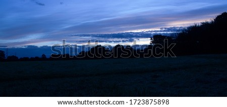 Field with clouds at dusk