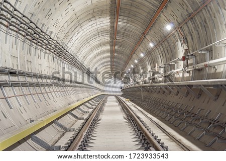 Railway underground tunnel which install running and conductor rail. Selective focus. Royalty-Free Stock Photo #1723933543