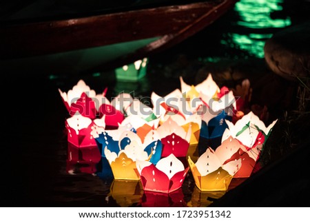 Color Asian paper lanterns reflecting light on water