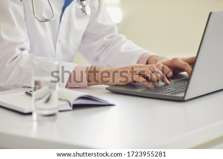Online doctor call concept. Online doctor typing message conference video chat call webcam using laptop gadget in clinic office.