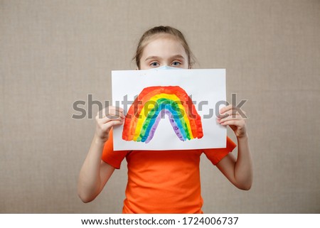 Little Caucasian Girl Holding Painted Rainbow During Covid-19 Quarantine As a Sign Of Hope. Let's All Be Well, Hope During Coronavirus Pandemic Concept