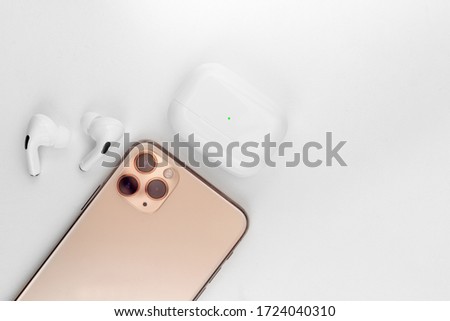 white wireless headphones next to a mobile phone.White background. copy space  Royalty-Free Stock Photo #1724040310