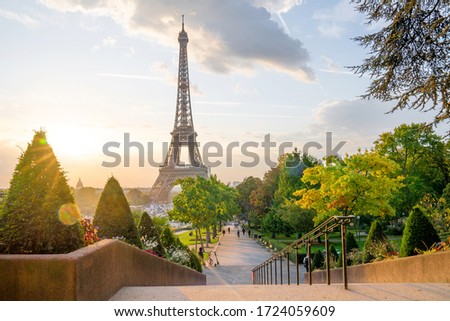 Eiffel Tower at sunrise illuminated with rising sun. Beautiful summer Paris cityscape.