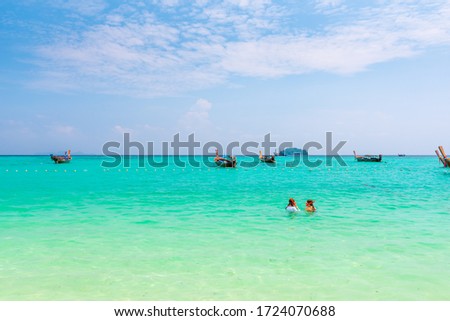 Two unidentifiable girls are snorkeling at Ko Lipe island, Thailand. Turquoise sea, pure water and coral reef with many tropical and exotic animals.