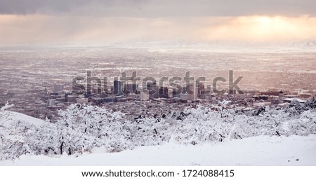 Salt Lake City from foothills covered in snow at sunset