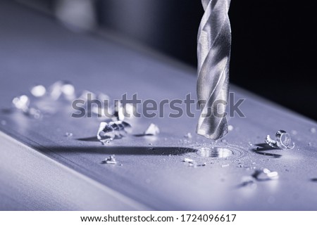 metal drill bit make holes in aluminum billet on industrial drilling machine with shavings. Metal work industry. multi cutting tool and end mill. Royalty-Free Stock Photo #1724096617