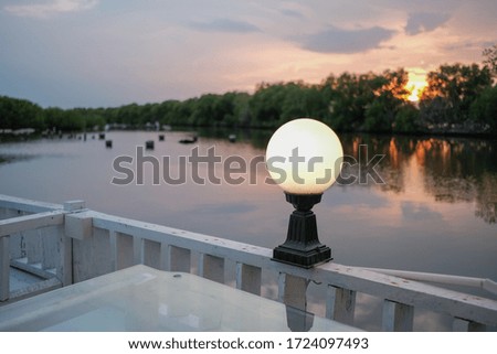 Round lantern on the wood fence with blur background in the twilight.  Round lantern isolated from blur background with lights. Copy space.