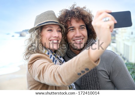 Cheerful couple taking picture with smartphone