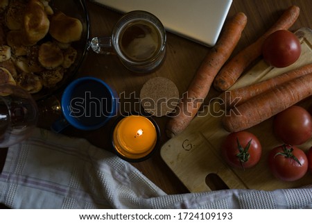 A flat-lay top view picture of healthy food in a country house on a cloudy Spring day with a moody candle in the middle