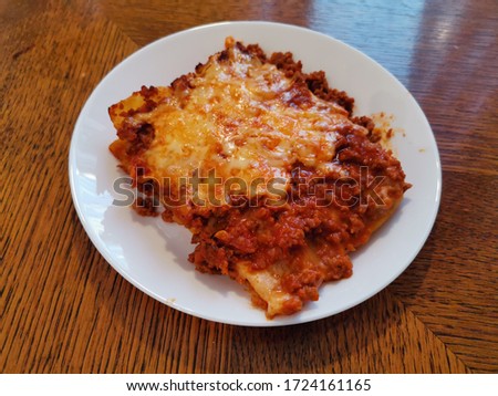 Closeup picture of a delicious lasagna served on a white plate