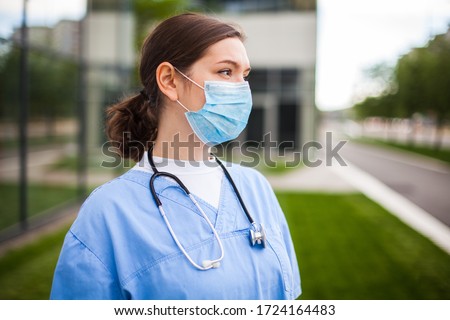 Serious female caucasian doctor looking away with worried facial expression,lost hope due to high mortality rate death toll,Coronavirus COVID-19 pandemic crisis,overworked exhausted EMS staff portrait Royalty-Free Stock Photo #1724164483
