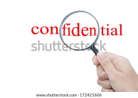 Hand Showing confidential Word Through Magnifying Glass  