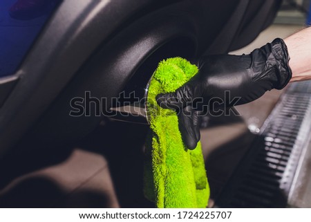 Car exhaust pipe with soap. Car wash background. close-up of a green rag