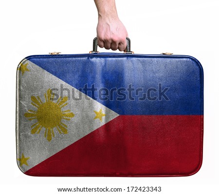 Tourist hand holding vintage leather travel bag with flag of Philippines
