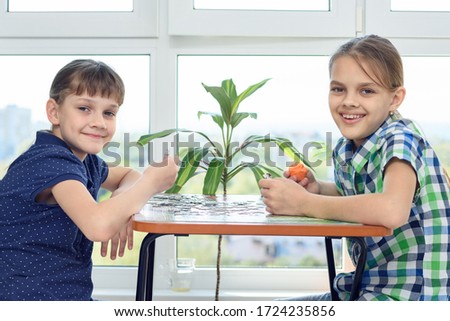 Children assemble a puzzle at home and happily look into the frame