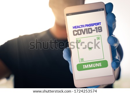 Man holding a smartphone with Immune digital passport for covid-19. Suitable for immunity passport app on the phone to monitorize the population movements at the end of the lockdown Royalty-Free Stock Photo #1724253574