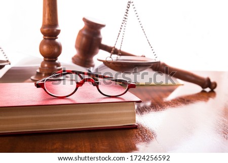 Glasses with a book, scales and a gavel on the table
