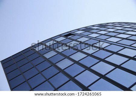 Windows. Modern business architecture. Fragment of highrise office building. Urban corporate real estate. Geometric background of rectangular frames, glass panels, parallel lines and reflection of sky