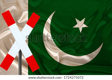 sign, stop, attention against the background of the silk national flag of Pakistan, the concept of border and customs control, violation of the state border, tourism restrictions