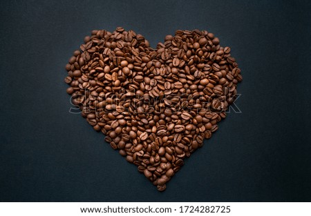 Heart of roasted, fresh coffee beans on a black background. Love. Still life. Horizontal photo in good quality.