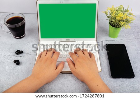 Workspace with female with laptop with blank green screen with notepad and cup of coffee
