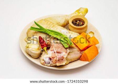 A set of products for chicken stock isolated on white background. Raw ingredients, fresh meat and ripe vegetables, spices
