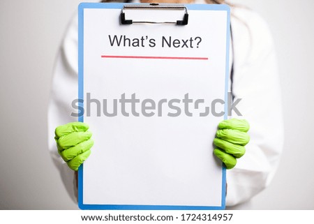 doctor in a white coat holds a letter with text what next
