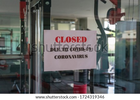 Closed sign with the words due to covid-19 coronavirus on a glass window in gym due to Covid-19 or Corona virus outbreak pandemic crisis. 