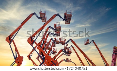 Aerial work platforms lined up of cherry picker  against blue sky with clouds, Aerial work platforms, AWP, elevating work platform. Royalty-Free Stock Photo #1724340751