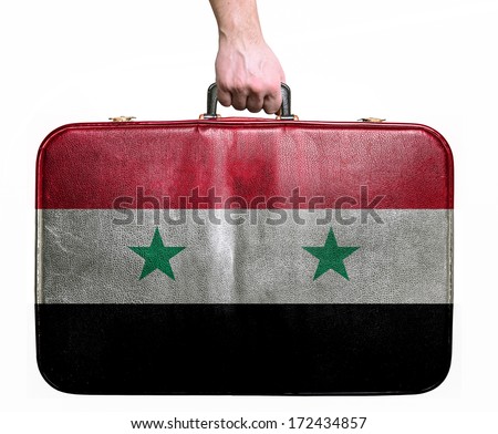 Tourist hand holding vintage leather travel bag with flag of Syria