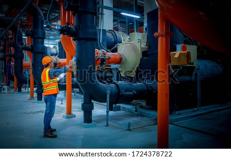 Engineer under checking the industry cooling tower air conditioner is water cooling tower air chiller HVAC of large industrial building to control air system. Royalty-Free Stock Photo #1724378722