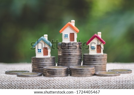 Mini house on stack of coins, Concept of Investment property, Investment risk and uncertainty in the real estate housing market. Royalty-Free Stock Photo #1724405467