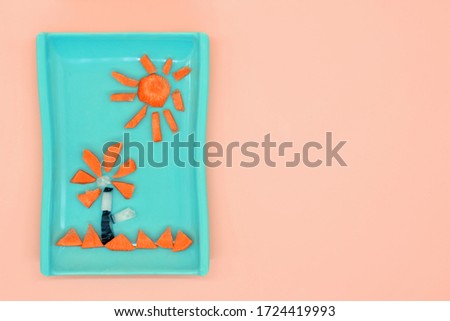 Creative food concept. Funny flower and sun in the sky made from vegetables.