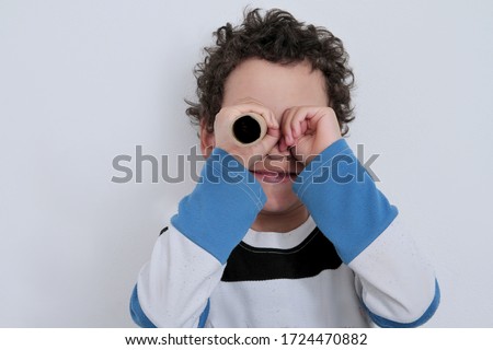 boy looking  through binoculars toilet paper roll on white background stock photo