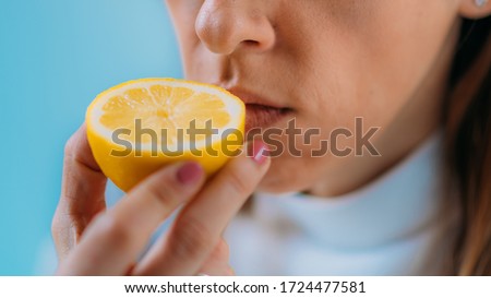 Anosmia or smell blindness, loss of the ability to smell, one of the possible symptoms of covid-19, infectious disease caused by corona virus. Woman Trying to Sense Smell of a Lemon Royalty-Free Stock Photo #1724477581