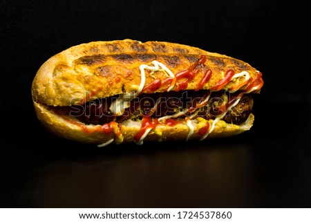 Hot dog on a black background, junk food