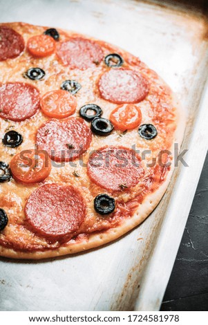 Fresh pepperoni pizza served on the rustic background. Selective focus. Shallow depth of field.