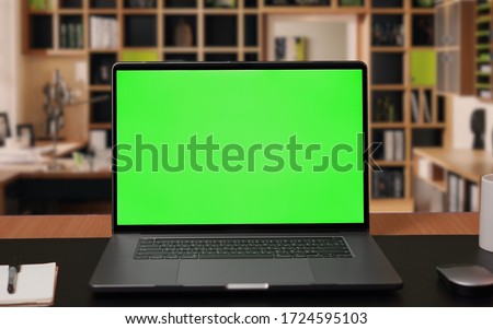 Laptop computer with Green screen Mock-up on working desk in office with no people Royalty-Free Stock Photo #1724595103