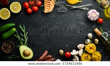 Background of cooking tagliatelle pasta and ingredients. Black stone background of Italian cuisine. Top view. Royalty-Free Stock Photo #1724611486