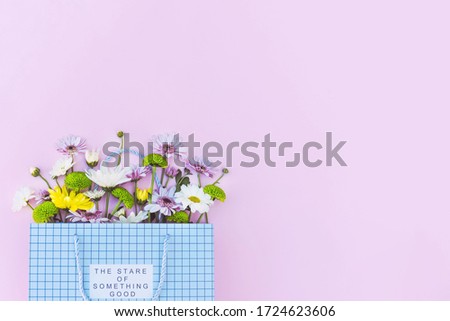 Beautiful flower arrangement in a gift bag on a pink background. 