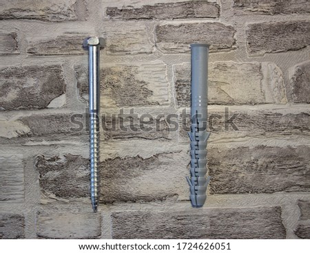 Anchor plug with universal wrench screw against a brick wall
