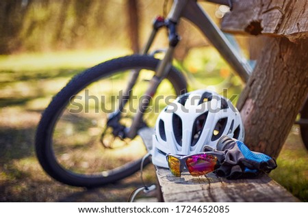 Outfit for bicycles, helmet, gloves on the bench on a sunny day.
 Royalty-Free Stock Photo #1724652085
