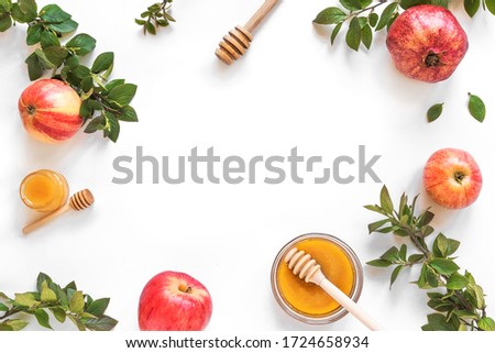 Rosh Hashanah jewish New Year holiday concept. Creative layout of traditional symbols - apples, honey, pomegranate isolated on white, top view, copy space. Royalty-Free Stock Photo #1724658934