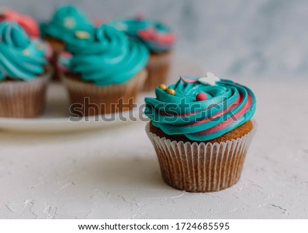 Turquoise cupcake in a white plate on a white background